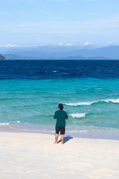 Man Standing on Sandy Beach by Ocean Stock-Fotos