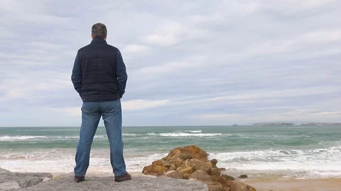 Man standing by the sea at the beach Stock Footage 104197897