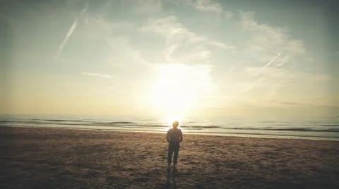 Man standing on seashore during sunset, graded Stock Footage 57390565