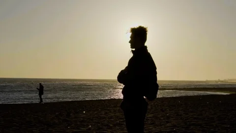 Man standing on the seaside. Beautiful sunset at the sea, beach. Stock Footage 80387907
