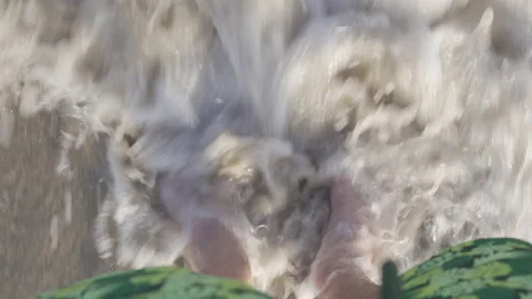 Man standing at shoreline, waves rolling in onto feet. Summer vacation concept. Stock Footage 159131925