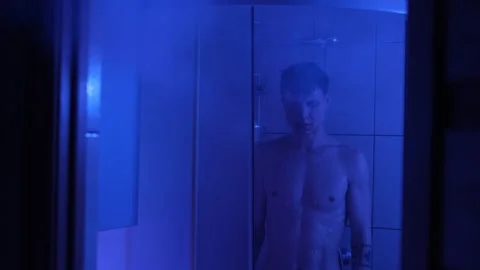 Man standing in the shower after a difficult emotional day, lost in deep Video stock 304235392