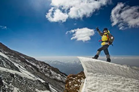 Man standing on a snow cornice in mountain sunrise Stock Photos