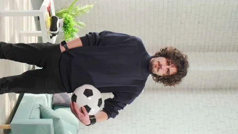 Man standing with soccer ball in front of the camera on bright room background. Stock Footage 151278464