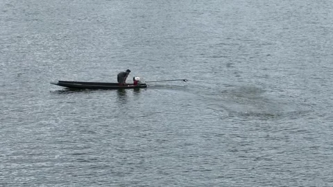 Man standing starting engine of longtail boat on the river, side view Video stock 248827754