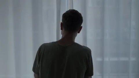 Man standing still by the window, struggling with social anxiety, panic disorder Stock Footage 311020091