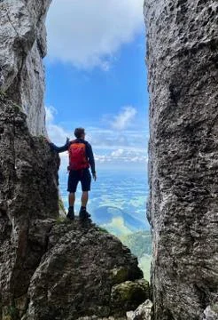 Man standing in stone window, mountain view, blue sky, Bavaria, Germany Stock Photos
