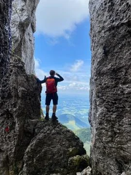 Man standing in stone window, mountain view, blue sky, Bavaria, Germany Stock Photos