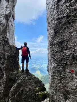 Man standing in stone window, mountain view, blue sky, Bavaria, Germany Fotos Stock