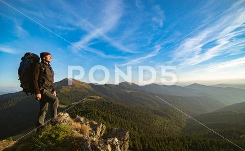 The man standing on the sunny mountain Stock Photos
