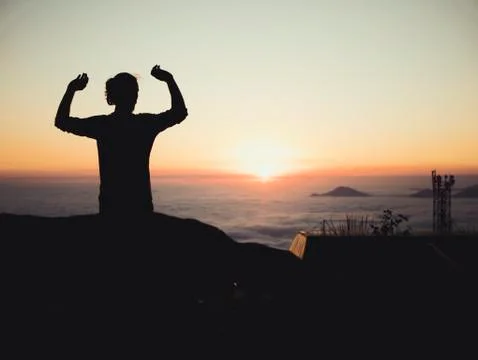 Man standing sunset clouds mountains sky skyline evening mourning Stock Photos
