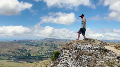 Man standing at Te Mata Peak with panoramic view of the hills and sky in New Stock Footage 305538239