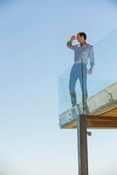 Man standing on the terrace and shielding his eyes Stock Photos