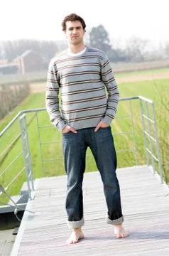 Man standing on a terrace, hands in pockets Stock Photos