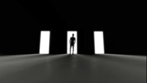 Man standing at three opening doors in darkness, light rays coming trough. Decis Stock Footage 154880314