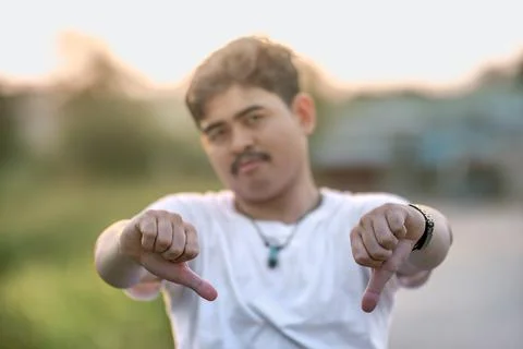 A man standing with a thumbs down. The man acted like someone was underesti.. Stock Photos