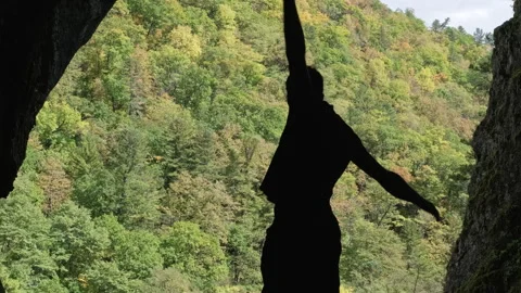Man Standing on Top of Cliff Next to Forest does a Warm-up Stock Footage 266819261