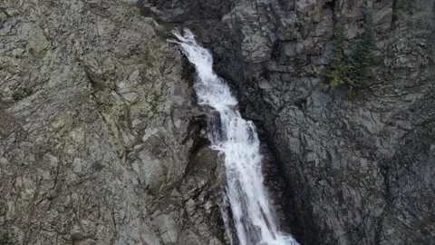 Man Standing on Top of Cliff Next to Waterfall Stock Footage 274513589
