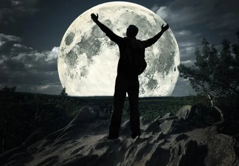 Man standing on the top of mountain looking at the moon Stock Photos