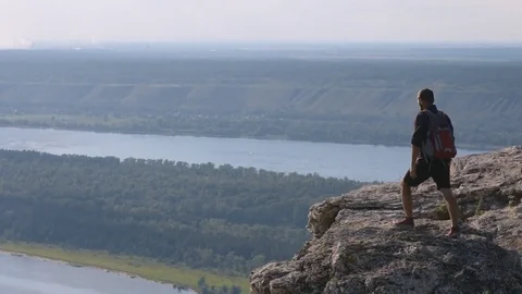 Man standing on top of a mountain with raised hands. The concept of courage Stock Footage 72587423