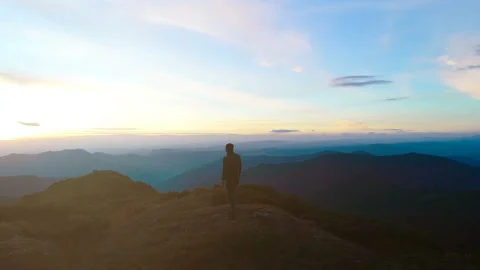 The man standing on the top of the mountain on the sunset background Stock Footage 95330389