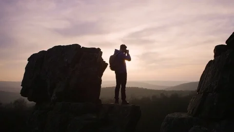 Man standing on top of the mountain taking photos at dusk Video stock 81617991