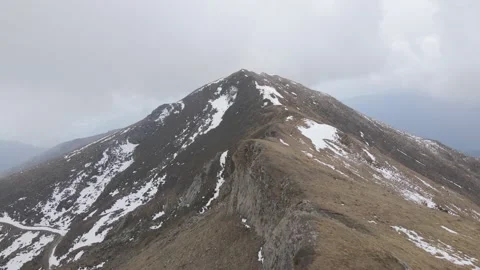Man standing on the top of the mountain watching the panorama while snowing Stock Footage 215917201