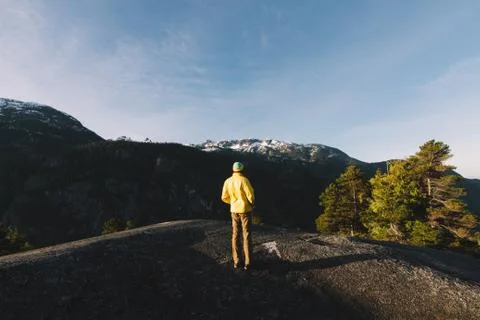 Man standing on the top of mountains while sunrise Stock Photos