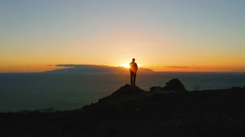 Man standing on top of rock with epic mountain viewpoint and enjoying colorful Stock Footage 226474593