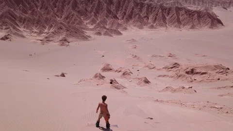 Man standing on the top of a sand dune Stock Footage 119334162