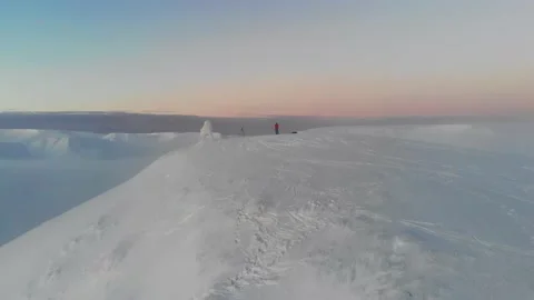 A man is standing on the top of a snow-capped mountain. View from the drone 스톡 동영상 147225019