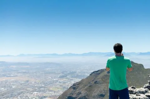 Man standing on top of table mountain in Cape Town South Africa taking photo Stock Photos
