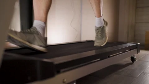 Man standing on treadmill side rails during break in workout. Close-up of a.. 스톡 동영상 332054842