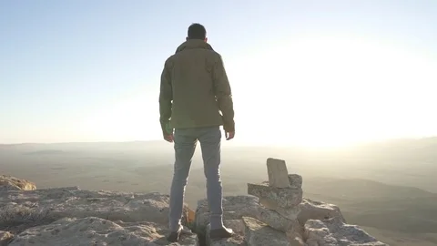 Man standing under the desert sun and lifts his armas Stock Footage 73080951