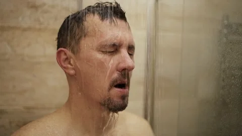 Man standing under flowing water in the shower. Close-up of a middle-aged m.. 스톡 동영상 332539892
