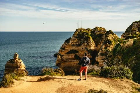 Man standing on a viewpoint overlooking the coast Stock Photos
