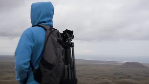 Man standing on volcanic landscape and looking around Stock Footage