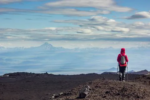 Man standing on volcanic slag with view on snowy volcanoes Stock Photos