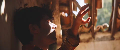 Man standing by the wall looking to the sky with his hand up Stock Footage 202267060