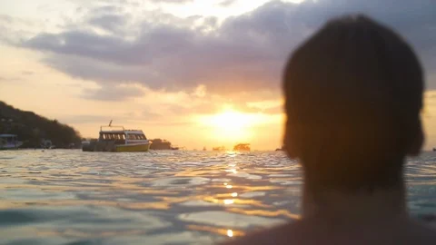 Man Standing in Water by Ocean Looking out at Sunset in Tropical Paradise. 스톡 동영상 113454038
