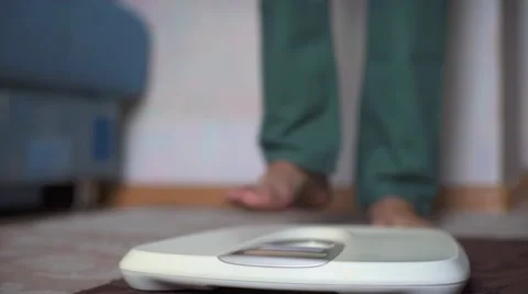 Man standing on weight scale Stock Footage 68942540