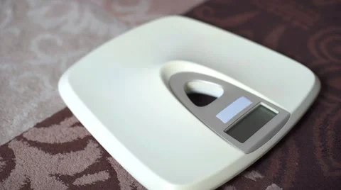 Man standing on weight scale Stock Footage 68942555