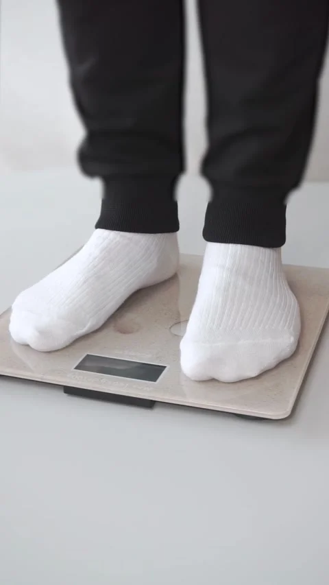 Man standing on weight scale. Weight loss concept Stock Footage 282442344