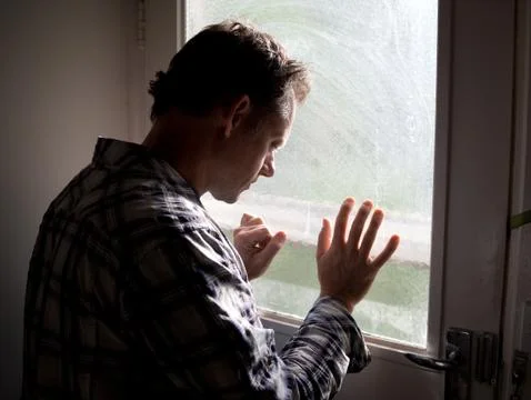 Man standing at window Stock Photos