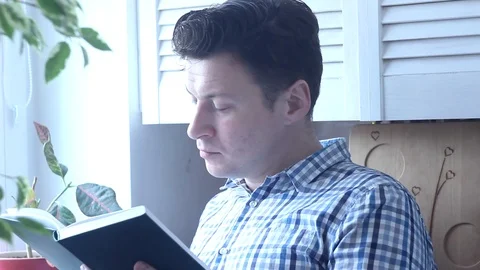 Man Is Standing In The Window Reading A Book Stock Footage 124009905