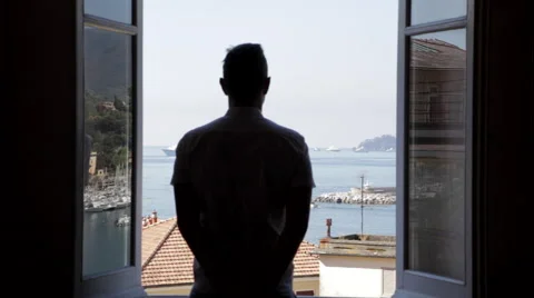 Man Standing in Window, Silhouetted by the Sun Stock Footage 65965107