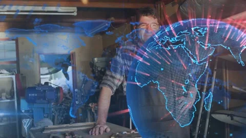 Man standing at workbench, holographic globe sweeping and revealing craftsman Stock Footage 321378060