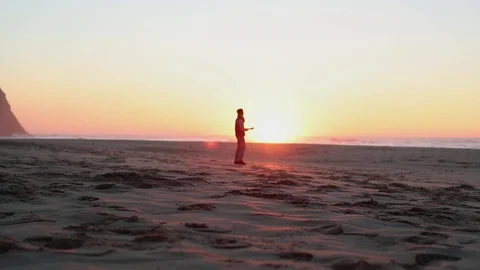A man stands on the against the background of the sun in the cloudless sky Stock Footage 130116509