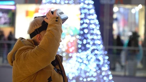 A man stands on a background of a Christmas tree in a shopping center with glass Stock Footage 86050856