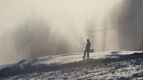 Man stands on the background of working snow cannons. Amazing view. Winter sport Video stock 97797618